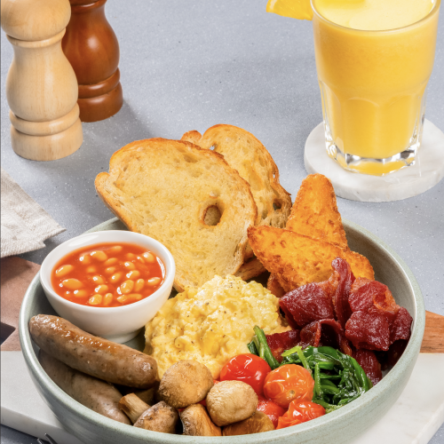 Full English Breakfast with scrambled eggs, bacon, sausages, baked beans, mushrooms, hash browns, toast and fresh orange juice